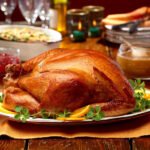 Pavo adobado dorado recién salido del horno sobre una bandeja